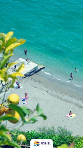 a group of people on a beach with the ocean at MAR-ISA Amalfi Coast in Vietri sul Mare