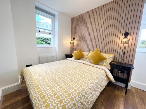 a bedroom with a bed and two tables and a window at Lovely Apartment, One Minute from Bournemouth Beach and Town. in Bournemouth