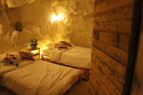 a bedroom with two beds in a stone room at 7 Caves Hotel in Al Jāyah