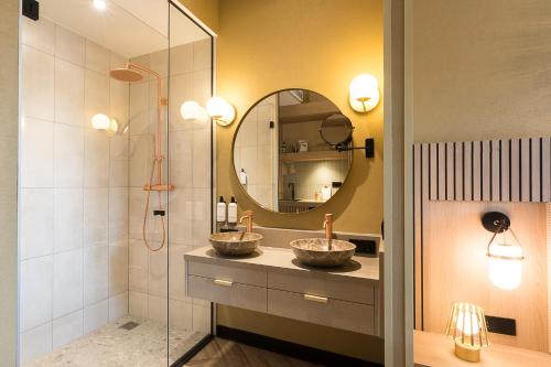 a bathroom with two sinks and a mirror at Boutique Hotel Helder I Kloeg Collection in Renesse