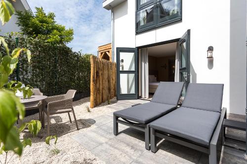 a patio with a couch and a table and chairs at Boutique Hotel Helder I Kloeg Collection in Renesse