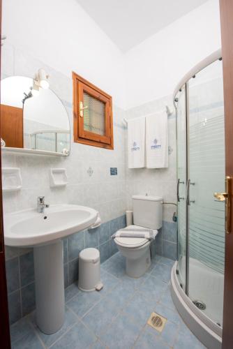 a bathroom with a sink and a toilet and a shower at Golden Sun in Agios Ioannis Pelio