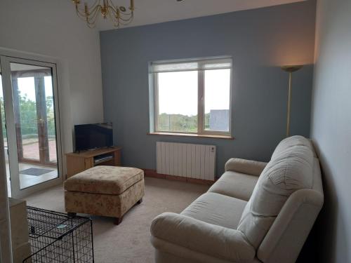 a living room with a couch and a tv at Two bed bungalow with sunroom and stunning views in Killybegs