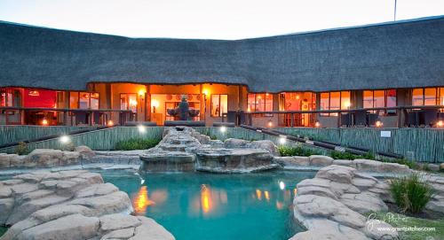 a house with a swimming pool in front of it at The Springbok Lodge in Nambiti Private Game Reserve