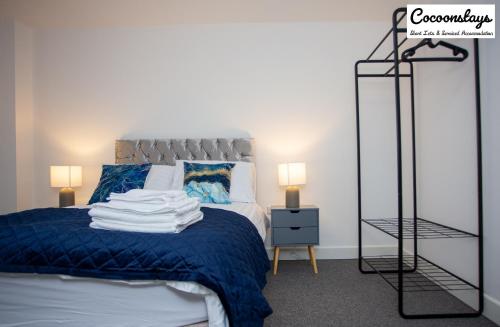 1 dormitorio con 1 cama con manta azul en Cocooonstays Stays Short Lets & Serviced Accommodation Slough, en Slough