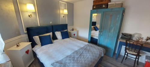 a bedroom with a blue bed and a mirror at Apartment Sabljaci by the Lake in Ogulin