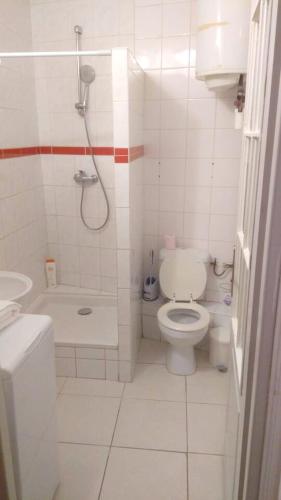 une salle de bain blanche avec toilettes et douche dans l'établissement Maison charmante à Montgeron avec terrasse, à Montgeron