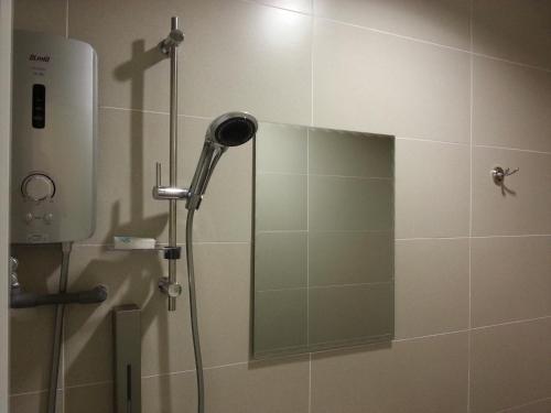 ducha con cabezal de ducha y espejo en Hotel Strawberry Fields, en Petaling Jaya