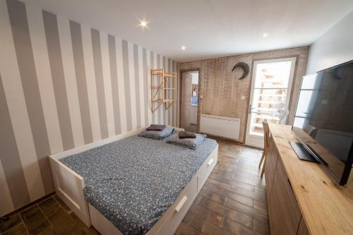 a small bedroom with a bed and a television at Venez Rêver Béziers CENTRE et GARE il y a plus cher mais c est moins bien in Béziers