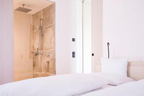 a bedroom with a shower and a white bed at Alpin Chalet Trinkl - adults only ab 16 Jahren in Bad Wiessee