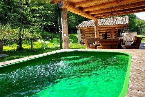 a swimming pool in a backyard with a wooden house at Koča na samem in Moravske-Toplice