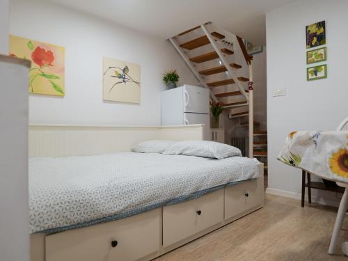 een kleine slaapkamer met een bed en een trap bij Apartment or room at Irena's in Piran