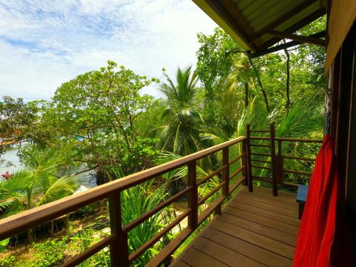 a wooden balcony with a view of the water at Eclypse de Mar Acqua Lodge in Bastimentos