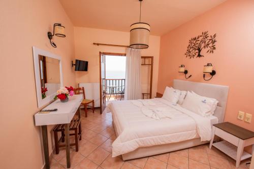 a bedroom with a bed and a table and a desk at Golden Sun in Agios Ioannis Pelio