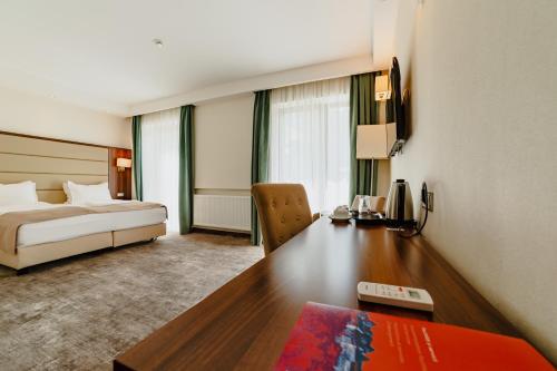 a hotel room with a bed and a desk at Radsor Hotel in Râşnov