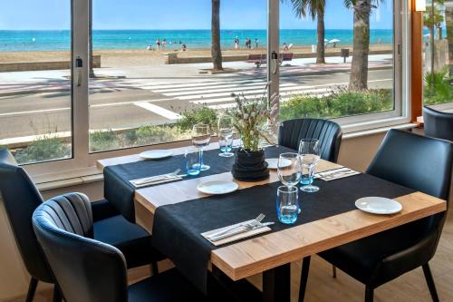 a dining room table with chairs and a glass of wine at 4R Casablanca Playa in Salou