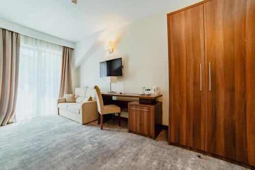 a hotel room with a desk and a tv at Radsor Hotel in Râşnov