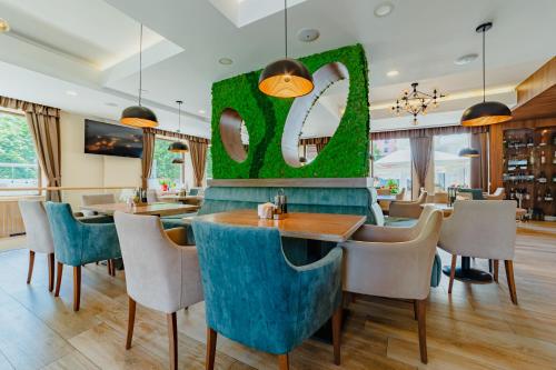 a restaurant with tables and chairs and a large letter s at Radsor Hotel in Râşnov