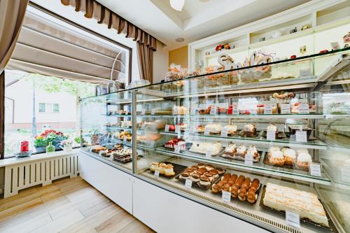 a bakery with a display case filled with pastries at Radsor Hotel in Râşnov