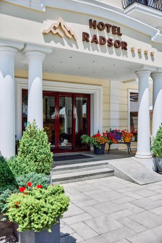 a hotel lobby with a hotel raider sign and flowers at Radsor Hotel in Râşnov