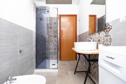 W łazience znajduje się prysznic i umywalka. w obiekcie Casa vacanze con giardino - Twiggy's House w mieście SantʼAntìoco