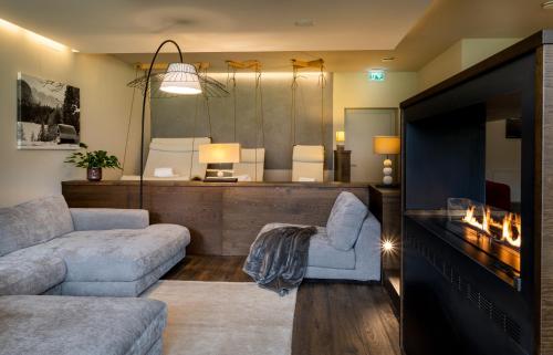 a living room with a couch and a tv at Hotel Franks in Oberstdorf