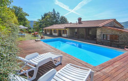 a swimming pool with two chairs and a house at B&B Borgo Valagnesi in Pratovecchio