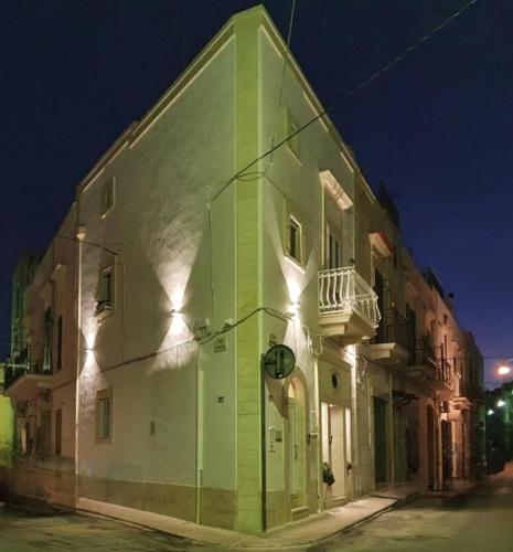 a white building with green paint on it at night at Dimora della Nonna-Luxury Home in Mola di Bari