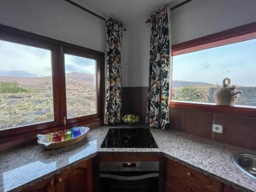 a kitchen with a sink and two large windows at Casa Las Huertas in La Vegueta
