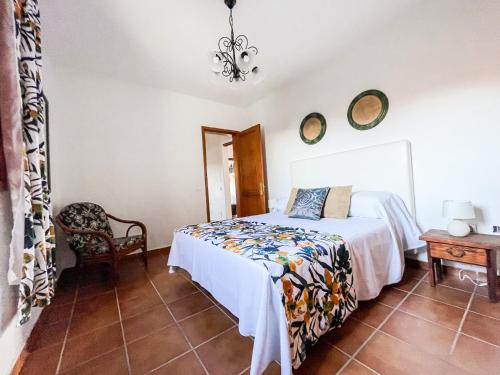 a bedroom with a bed and a table and a chair at Casa Las Huertas in La Vegueta
