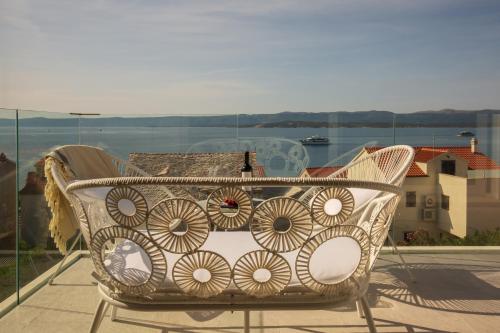 a chair on a balcony with a view of the water at Bol Summer Residence in Bol