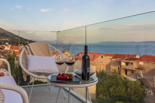a table with two glasses of wine on a balcony at Bol Summer Residence in Bol