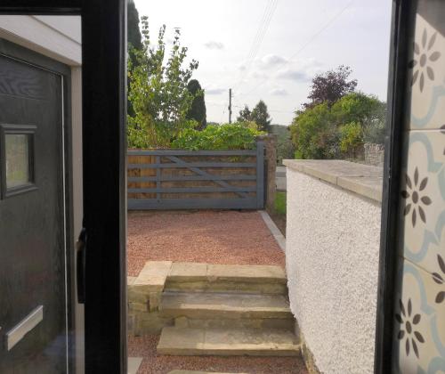 a door leading to a patio with a fence at Bowkett Cottage in Cinderford