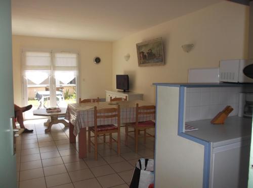 une cuisine et une salle à manger avec une table et des chaises dans l'établissement résidence Etoile de mer, à Saint-Pair-sur-Mer