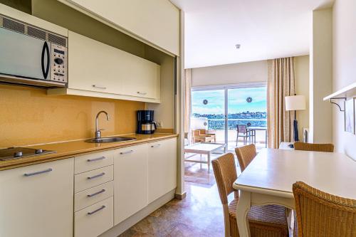 a kitchen with a table and a dining room at Aparthotel Cordial Mijas Golf in Mijas