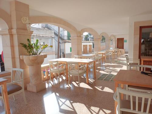 una fila di tavoli e sedie in un ristorante di Hotel Nou Can Guillem a Cala Figuera
