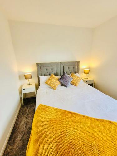 a bedroom with a large white bed with two lamps at Primrose House in Whitefield