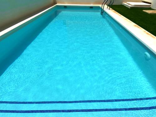 a large swimming pool with blue water at Villa Isla Plana, right by the sea - Grande in Isla Plana