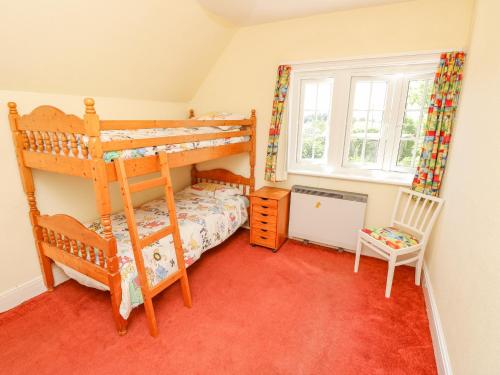 a bedroom with two bunk beds and a window at Ladylands Cottage in Newport