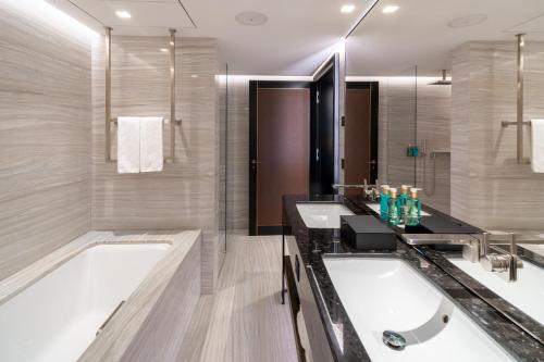 a bathroom with two sinks and a tub at FIVE Zurich - Luxury City Resort in Zürich