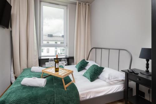 1 dormitorio con 1 cama con mesa y ventana en Apartment Mistral Gdynia with Parking by Renters, en Gdynia