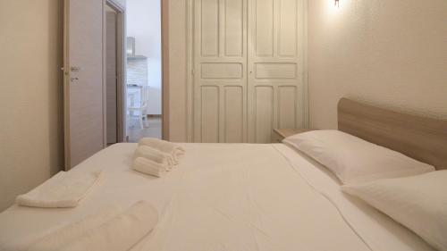- un lit blanc avec 2 serviettes dans l'établissement Welcomely - Villa Paola B, à Costa Rei