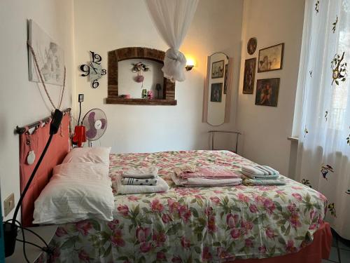 1 dormitorio con 1 cama con colcha de flores en Casetta Sirenetta, en Castiglione della Pescaia