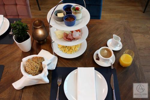 a table with plates of food and cups of coffee at ARGENTA Living 16 in Künzell