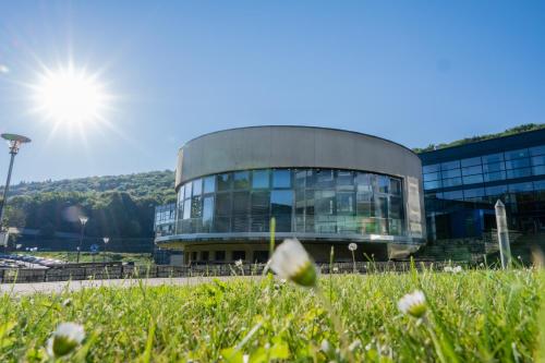 a large glass building with the sun in the sky at Sportcampus Saar in Saarbrücken