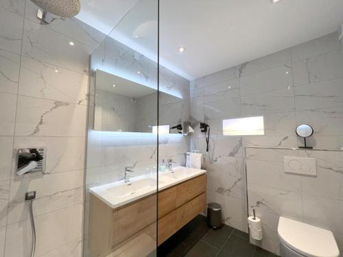 a bathroom with a sink and a toilet and a mirror at Hotel Schlossblick Chiemsee in Prien am Chiemsee