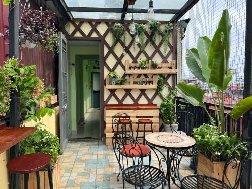 an outdoor patio with tables and chairs and plants at Hanoi EcoStay 2 hostel in Hanoi