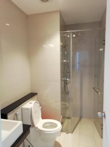 a bathroom with a toilet and a glass shower at Apartment Universal in Galle