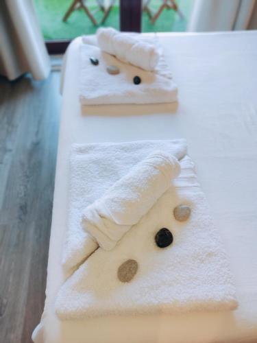 two towels with faces on them on a table at The Surf Studio - Ericeira in Ericeira