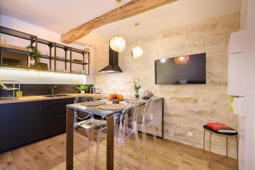 cocina con mesa con sillas y TV en Duplex standing 7min➤Fontainebleau-INSEAD⎮45min➤Paris en Veneux-les-Sablons